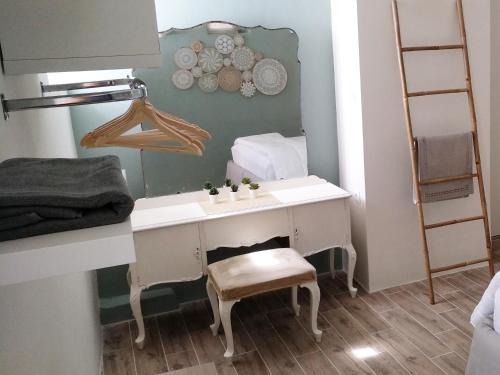 a bathroom with a desk with a chair and a shelf at Yalitzi in Symi
