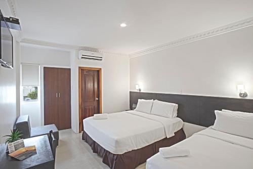 ein Hotelzimmer mit 2 Betten und einem Schreibtisch in der Unterkunft Hotel La Ría Playas in Playas