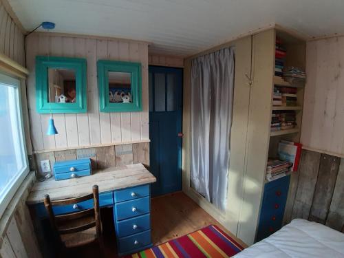 een kleine kamer met een bureau en een bed bij De Flierefluiter in Nutter