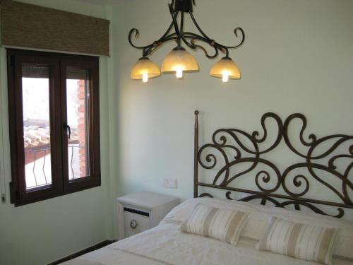 um quarto com uma cama e um lustre em Casa Artigot em Gea de Albarracín