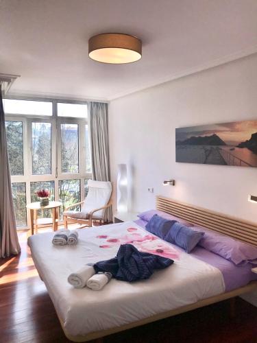 a bedroom with a large bed with towels on it at Apartamento PioXII Center in San Sebastián