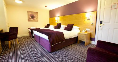 a hotel room with two beds and a chair at Ayre Hotel & Ayre Apartments in Kirkwall