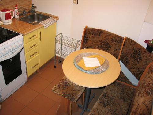 a kitchen with a table with a hat on it at Taneček - malý apartmán u rodinného domu in Stvolínky