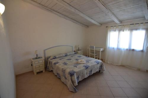 a bedroom with a bed and a table and a window at Cielo e mare in Golfo Aranci