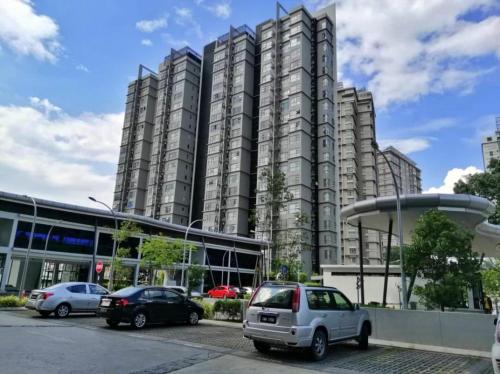 a large building with cars parked in a parking lot at The ComfyHauz # Cyberjaya in Cyberjaya