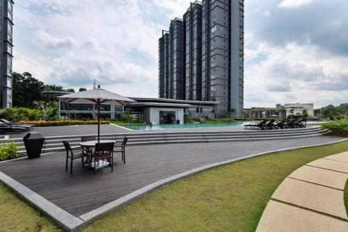 a patio with tables and an umbrella and buildings at The ComfyHauz # Cyberjaya in Cyberjaya
