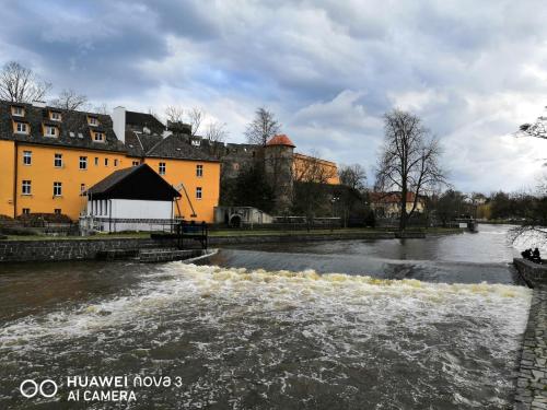 a river in a city with a building at Penzion Na Svahu in Cheb