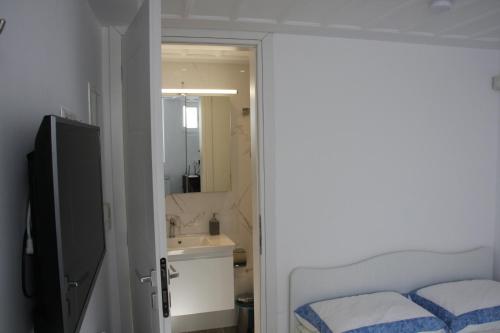 a bathroom with a bed and a sink and a mirror at Andoni's House in Pitrofós