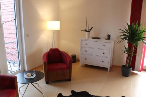 a living room with a red chair and a dresser at "Fahner Mühle" in Gierstädt