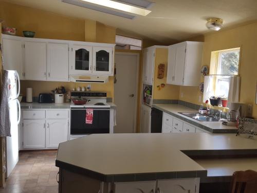 a kitchen with white cabinets and a counter top at River Falls Lodging -Black Hills, South Dakota in Hot Springs