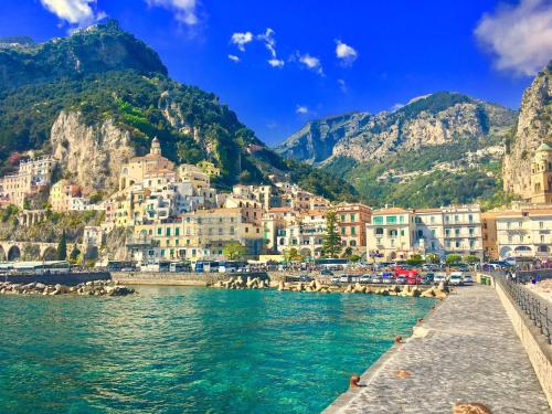 vista su una città sull'acqua con montagne di Casa Annamaria a Napoli