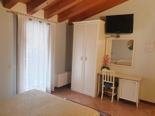 a bedroom with a bed and a desk and a tv at Villa Serena Agriturismo in Montebelluna