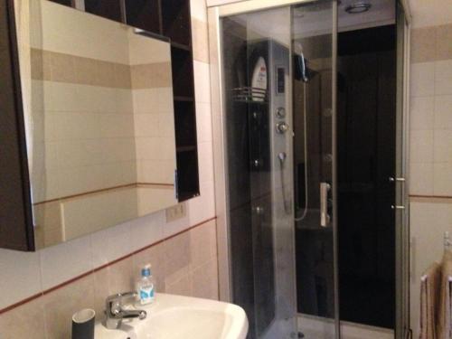 a bathroom with a sink and a shower with a mirror at Appartamento Antonio in Malo