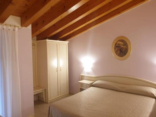 a bedroom with a bed in a room with wooden ceilings at Villa Serena Agriturismo in Montebelluna