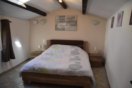 une chambre avec un lit et deux tables de nuit dans l'établissement Gîte La Lichère - Le Romarin, à Saint-Montan