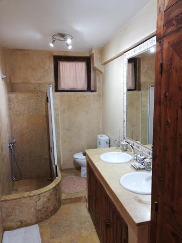 un bagno con due lavandini, una doccia e un WC di Taghazout Beach a Taghazout