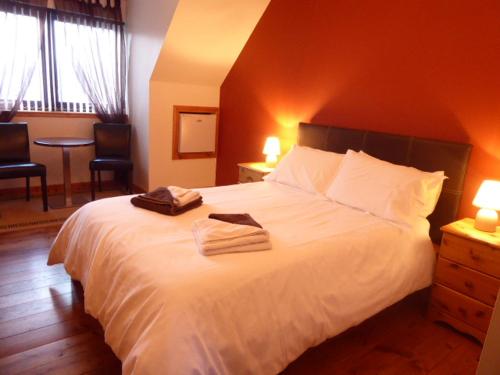 1 dormitorio con 1 cama blanca y 2 toallas en Dacama House, en Ullapool