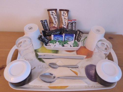 ein Tablett mit Toilettenpapier und Küchenutensilien auf dem Tisch in der Unterkunft Dacama House in Ullapool