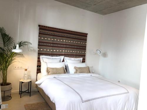 1 dormitorio con 1 cama blanca grande y cabecero de madera en Casa Figa 39, en Zagreb