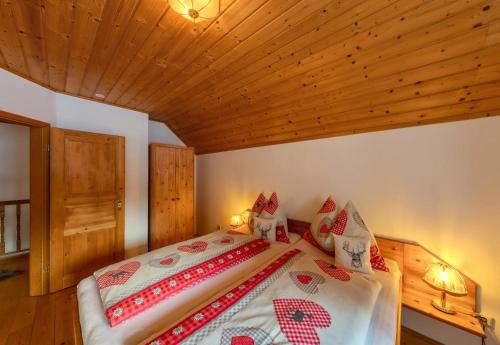 a bed in a room with a wooden ceiling at Apartment Almhaus Innerkrems in Innerkrems