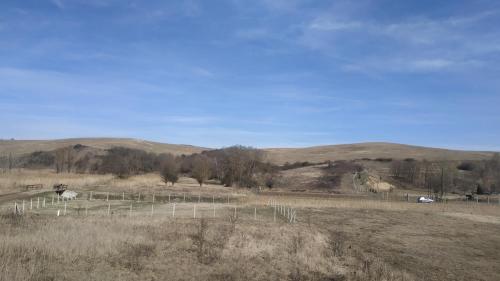 a field with a fence in the middle of a field at Miklós Fogadó és Étterem in Mátraterenye
