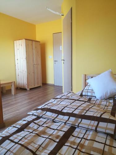 a bedroom with a bed and a cabinet in it at Miklós Fogadó és Étterem in Mátraterenye