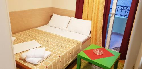 a small bedroom with a bed and a green table at Apartments Pier in Budva