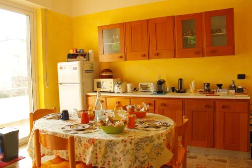 a kitchen with a table and a white refrigerator at VillAlbero B&B in Inveruno