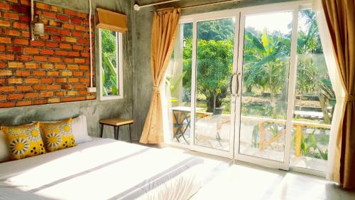 a bedroom with a bed and a large window at Home No.9 in Ko Lanta