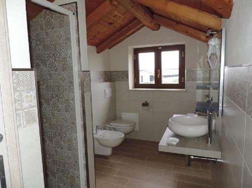 a bathroom with two toilets and a sink and a window at Il Bambuseto in Fossano