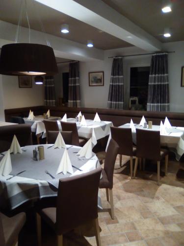 a restaurant with tables and chairs with white napkins on them at Landgasthof Kirchmayer in Farchant