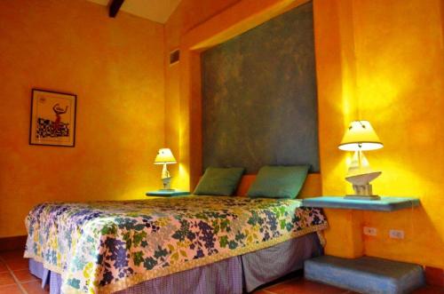 a bedroom with a bed with two lamps on it at Solyar Luxury Spanish Beachfront Home in Pochomil