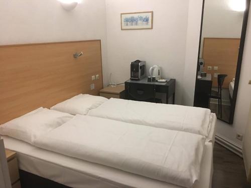 1 dormitorio con 2 camas blancas y espejo en Parkhotel Villa des Effats Vielsalm, en Vielsalm