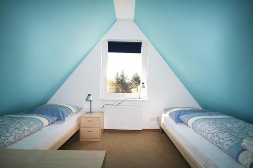 zwei Betten in einem Zimmer mit Fenster in der Unterkunft Gönndyr in Travemünde