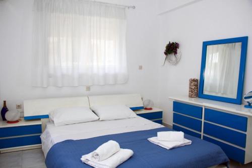 a bedroom with a blue and white bed and a mirror at Marina Beach House in Lartos
