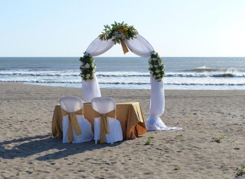 a table and chairs on the beach with a wedding arch at Solyar Luxury Spanish Beachfront Home in Pochomil