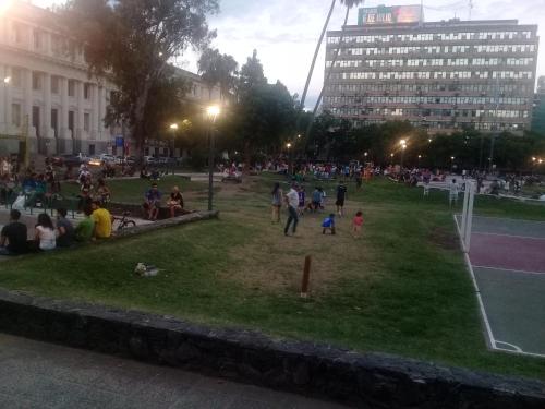 a crowd of people sitting in a park at night at Excepcional dpto frente a Plaza de la Intendencia in Córdoba