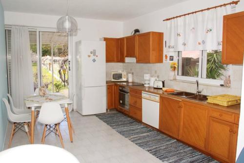a kitchen with wooden cabinets and a white refrigerator at Marina Beach House in Lartos