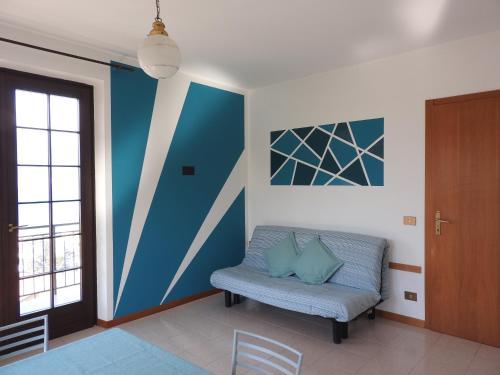 sala de estar con sofá y pared de acento azul en New Piccolo Residence, en Malcesine