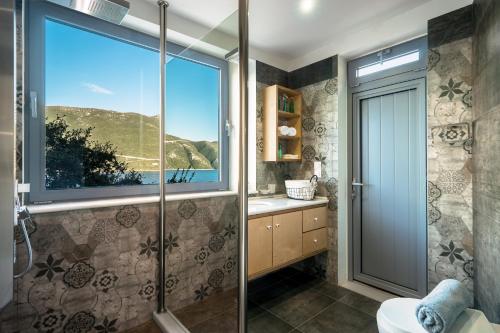 a bathroom with a shower and a large window at Soul Beach Suites in Vasiliki