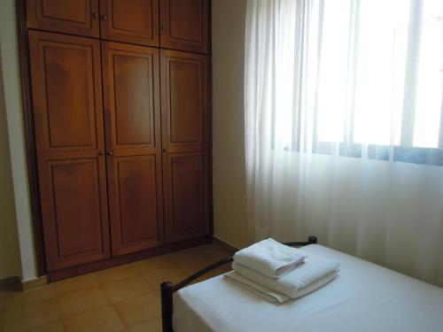 a bedroom with a bed with towels on it at Erofili in Pefkochori