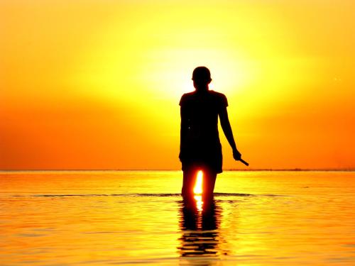 a man walking on the beach at sunset at Solyar Luxury Spanish Beachfront Home in Pochomil