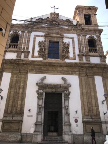 a man walking past a tall building at Ai Tre Mercati in Palermo