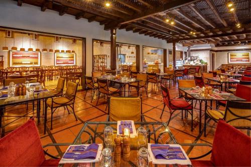 a restaurant with tables and chairs in a room at Porta Hotel Antigua in Antigua Guatemala