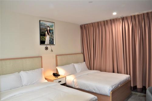 a hotel room with two beds and a window at LIC Plaza Hotel in Queens