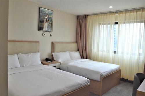 a hotel room with two beds and a window at LIC Plaza Hotel in Queens
