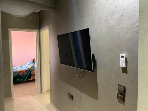 a flat screen tv on the wall of a bedroom at Agadir Holiday Apartment in Agadir