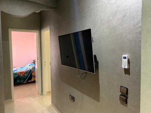 een flatscreen-tv aan de muur van een slaapkamer bij Agadir Holiday Apartment in Agadir