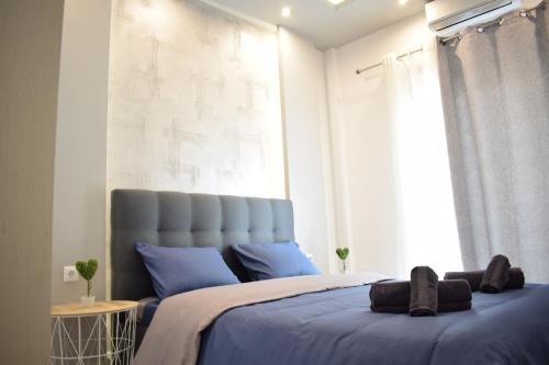 um quarto com uma cama com almofadas azuis e uma janela em Central Luxury Apartment in Thessaloniki em Tessalônica