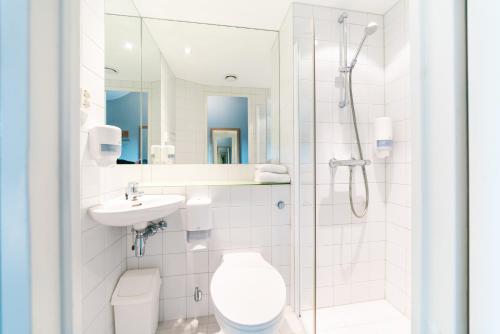 a bathroom with a toilet and a sink and a shower at Smarthotel Forus in Stavanger